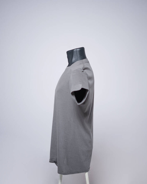 Graue Farbe Blanko-T-Shirt Vorlage für Männer, Seitenansicht, natürliche Form auf unsichtbare schwarze Schaufensterpuppe, für Ihre Attrappe zu drucken, isoliert auf schlichtem weißem Hintergrund. Freier Platz für Ihre Anzeige. - Foto, Bild