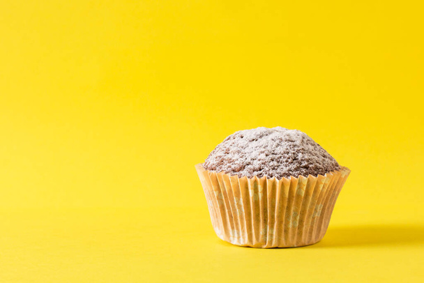 zelfgemaakte muffin op een gele achtergrond - Foto, afbeelding