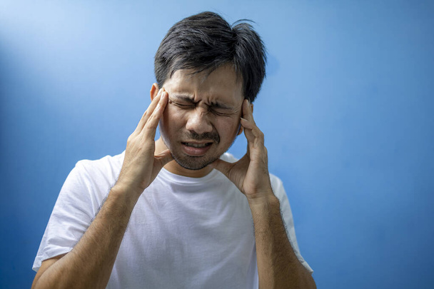 Fiatal ázsiai férfi szenved fejfájás és migrén, Feszültség. - Fotó, kép