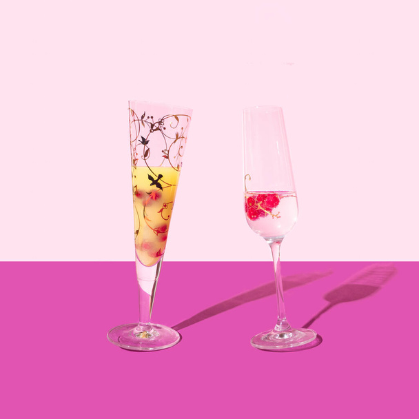 Dança óculos conceito elegante. Um copo de cocktail e uma taça de champanhe. Arranjo contra roxo e rosa claro. - Foto, Imagem