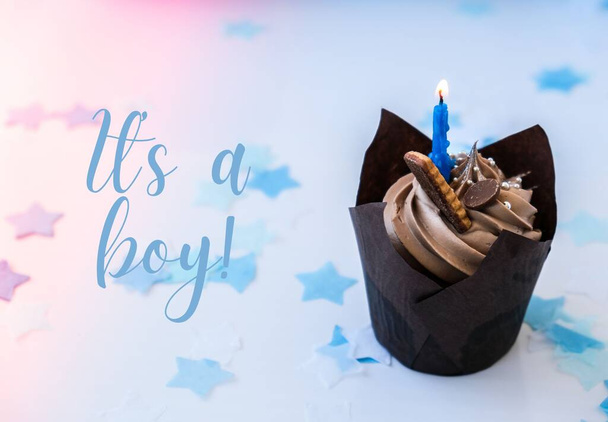 Baby shower It is a boy text greeting card. Chocolate cupcake with candle. Holiday. Celebration background. - Photo, Image