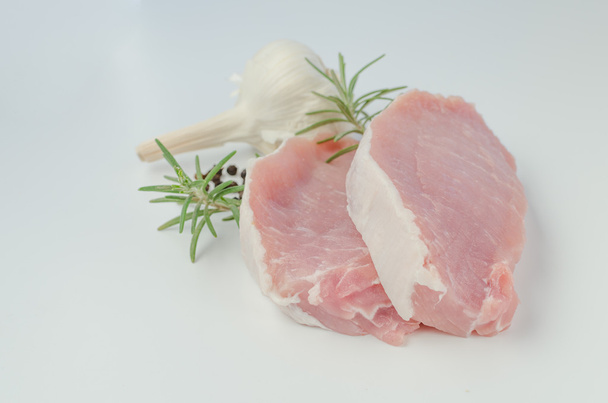 Сырая свиная отбивная с розмарином и чесноком
 - Фото, изображение
