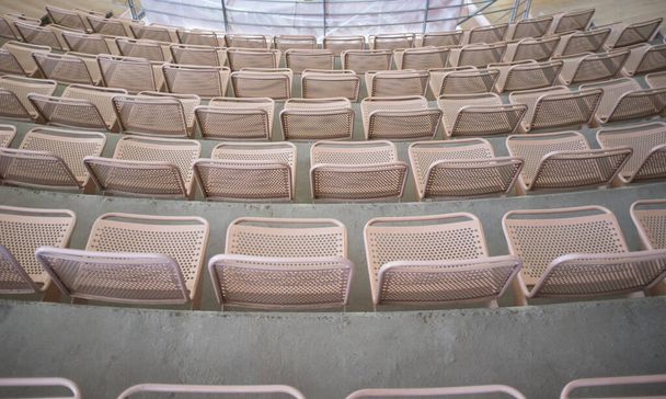 アリーナのグランドスタンドの金属製の席がいっぱいです。半円形の配置 - 写真・画像