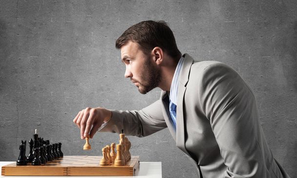 Concentrated businessman playing chess game - Foto, imagen