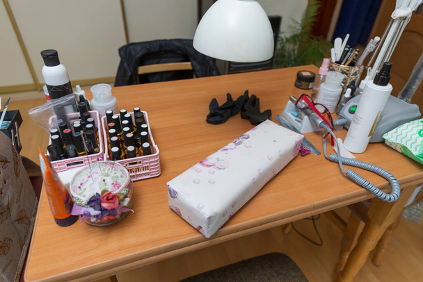 Workplace of a manicurist at home in a pandemic. Close up of antiseptics and nail polishes - Photo, Image