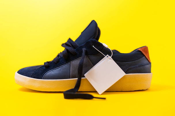 Male's new sneaker made of blue leather on a yellow background. Close up. Mock up. - Photo, Image