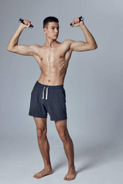 sporty man holding dumbbells in hands biceps workout exercise lifestyle - Fotografie, Obrázek