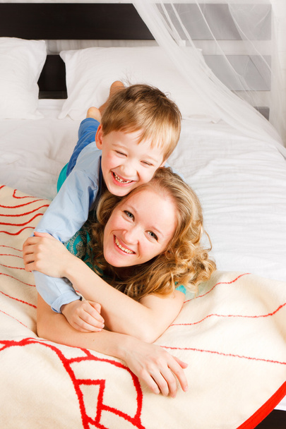 vrouw met een zoon op een bed - Foto, afbeelding
