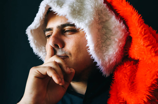 Muž v klobouku Santa Clause drží nos a bere heroin. Nový rok2020. Drogově závislý dealer. Nebezpečný zvyk. Nezdravý životní koncept. - Fotografie, Obrázek