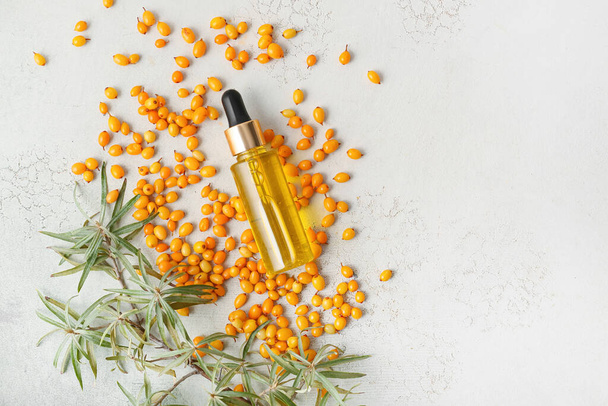 Bottle of sea buckthorn essential oil on light background - Photo, Image