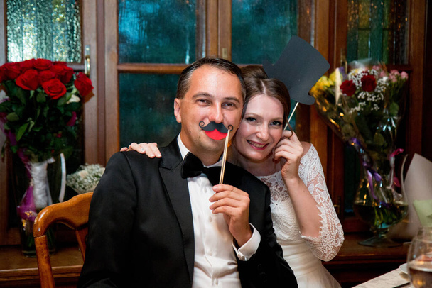 Svatba v Moskvě. 40 let. Nevěsta a ženich sedí v černých maskách - Fotografie, Obrázek