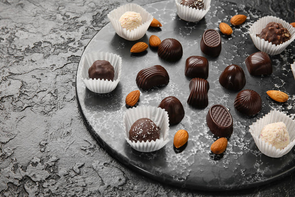 Sladké čokoládové bonbóny s ořechy na tmavém pozadí - Fotografie, Obrázek