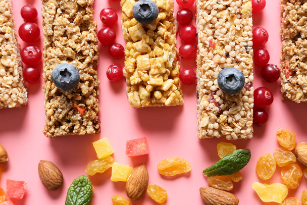 Healthy cereal bars, berries and nuts on color background - Photo, Image