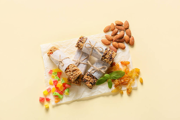 Gezonde granen bars, rozijnen en noten op kleur achtergrond - Foto, afbeelding