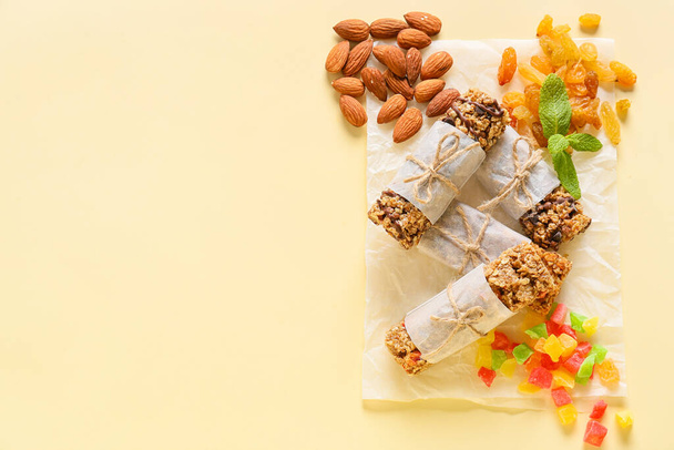 Gesunde Müsliriegel, Rosinen und Nüsse auf farbigem Hintergrund - Foto, Bild