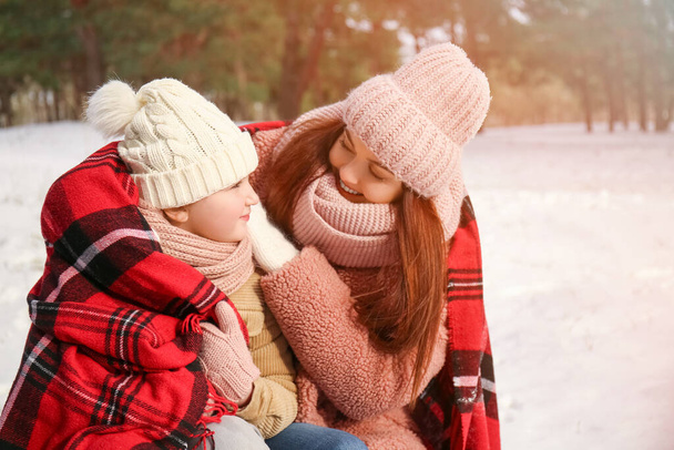 Gelukkige moeder en haar dochtertje in het park op winterdag - Foto, afbeelding