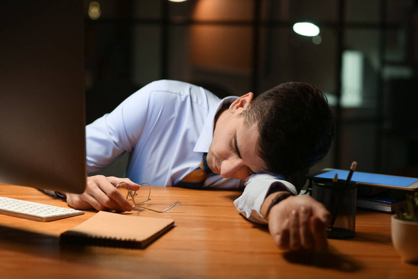 Tired businessman sleeping in office late at night - Foto, Imagem