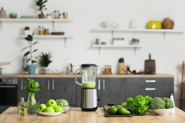 Blender with healthy smoothie and ingredients on table in kitchen - Photo, Image