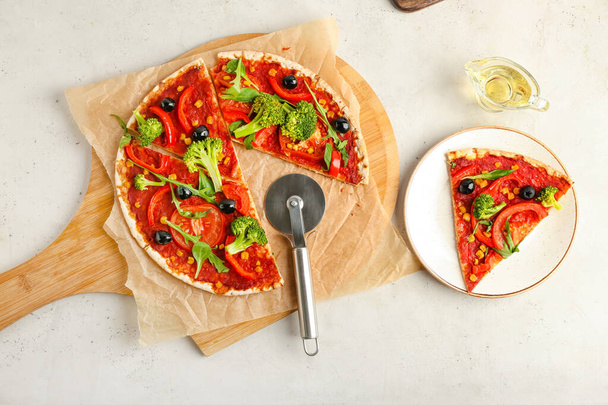 Board with tasty vegetarian pizza and knife on light background - Photo, Image