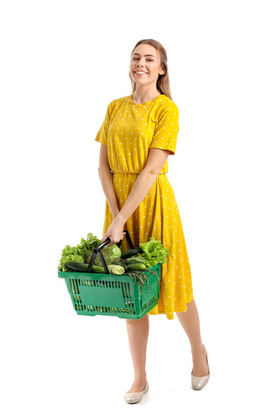 Jovem e cesta de compras com legumes frescos no fundo branco - Foto, Imagem