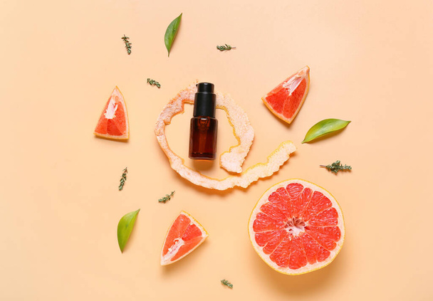 Composition with bottle of essential oil and grapefruit on color background - Fotó, kép
