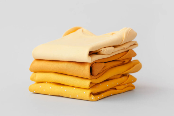 Stack of baby clothes on grey background - Foto, afbeelding