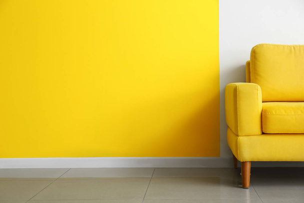 Comfortable armchair near color wall - Zdjęcie, obraz