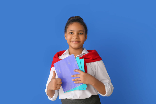 Cute African-American schoolgirl on color background - Photo, Image