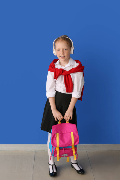 Милая маленькая школьница на цветном фоне - Фото, изображение
