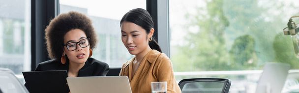 asiático e africano americano gestores olhando para laptop enquanto trabalhava no escritório, banner - Foto, Imagem