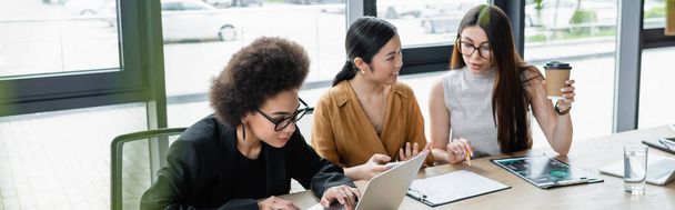 interraciale zakenvrouwen werken in de buurt van Afrikaanse Amerikaanse manager typen op laptop, banner - Foto, afbeelding