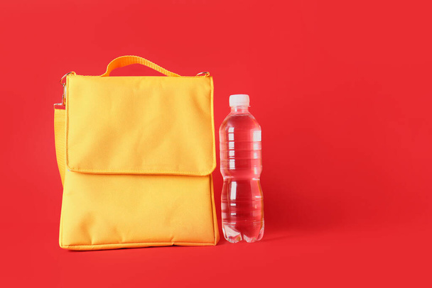 Sac boîte à lunch et bouteille d'eau sur fond de couleur - Photo, image