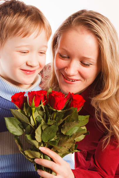 γυναίκα με ένα γιο και με την ανθοδέσμη των κόκκινων τριαντάφυλλων - Φωτογραφία, εικόνα
