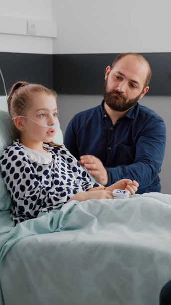 Arzt bespricht Krankheitsbehandlung mit krankem Kind Patient und Vater während ärztlicher Untersuchung - Foto, Bild
