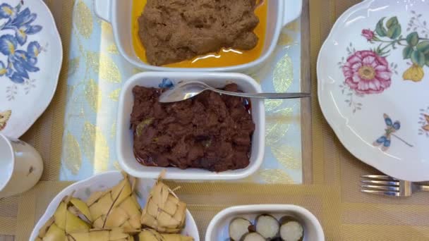 Maleisische lokale traditionele gerechten, lemang, ketupat, ketupat palas en andere eten tijdens eid mubarak of bekend als Hari Raya Aidilfitri viering. Eet samen met curry of rendang. - Video