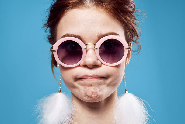 emotional woman wearing sunglasses fluffy earrings face close up - Foto, Imagen