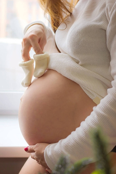 беременная девушка с сапогами в ожидании ребенка - Фото, изображение