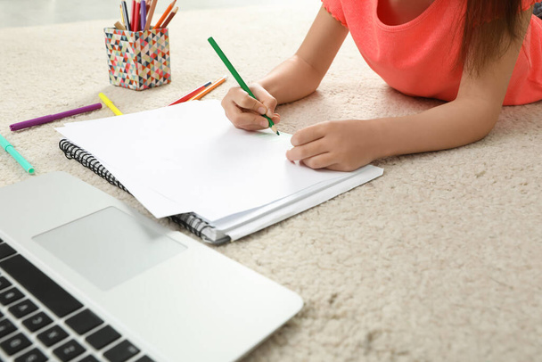 Petite fille dessin sur papier avec crayon à la leçon en ligne à l'intérieur, gros plan. Enseignement à distance - Photo, image