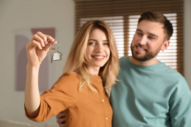Happy young couple with key in new house, focus on hand - 写真・画像