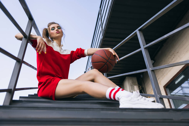 Beautiful adorable young girl in retro 90s fashion style, outfits posing on stairs, outdoors. Concept of eras comparison, beauty, fashion and youth. - Foto, Bild