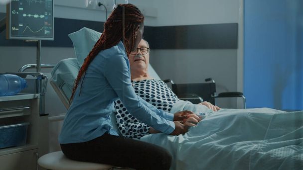 Afrikai amerikai barát meglátogatja idős beteg kórházi kórteremben - Fotó, kép