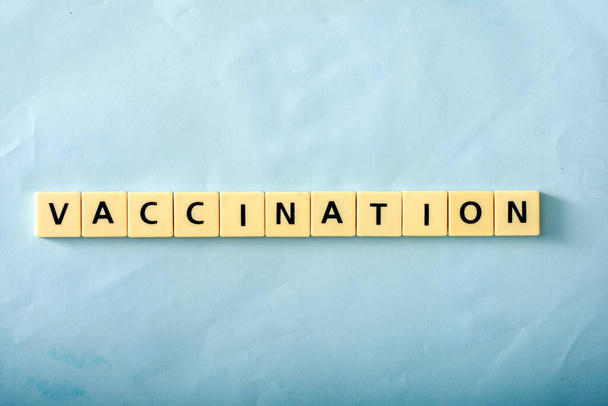 Palabra de vacunación sobre fondo azul - Foto, imagen