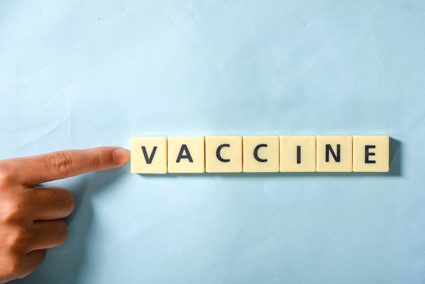 Дети вручную заполняют слово вакцины на головоломке - Фото, изображение