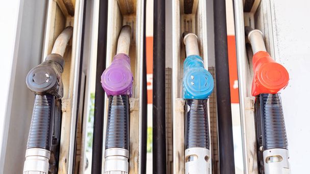 Pistolets de distribution de carburant multicolores dans les stations-service pour différents types d'essence. Fluctuations du coût du carburant. - Photo, image
