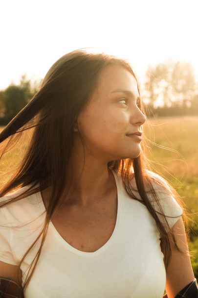 счастливая девушка с длинными черными волосами на пшеничном поле. Он наслаждается счастливыми моментами своей жизни.. - Фото, изображение