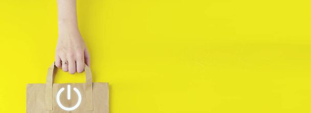 Перероблений коричневий паперовий сумка в руці з кнопкою голограми Піктограма на жовтому тлі, плоска. Розпочніть бізнес-концепцію. Концепція підсилення
 - Фото, зображення
