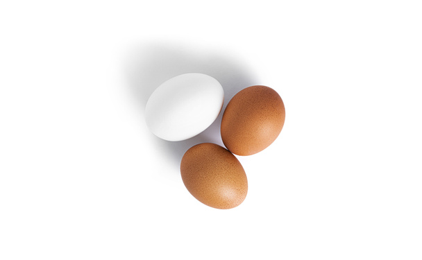Jaja są izolowane na białym tle. Jaja brązowe i białe. - Zdjęcie, obraz