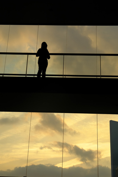 mujer en el edificio moderno al atardecer
 - Foto, Imagen