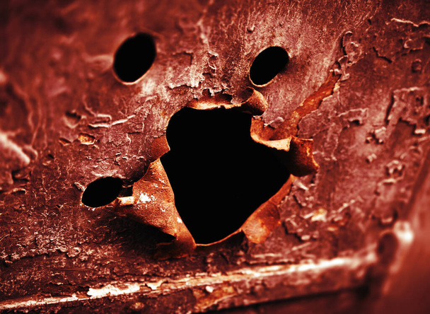 Vieille porte de communication métallique sur le mur de la vieille maison avec des trous en forme de visage avec une bouche criante - Photo, image