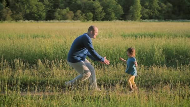Der junge Vater rennt die Straße entlang, um seine kleine Tochter zu treffen. Sommer und Sonnenuntergang - Filmmaterial, Video